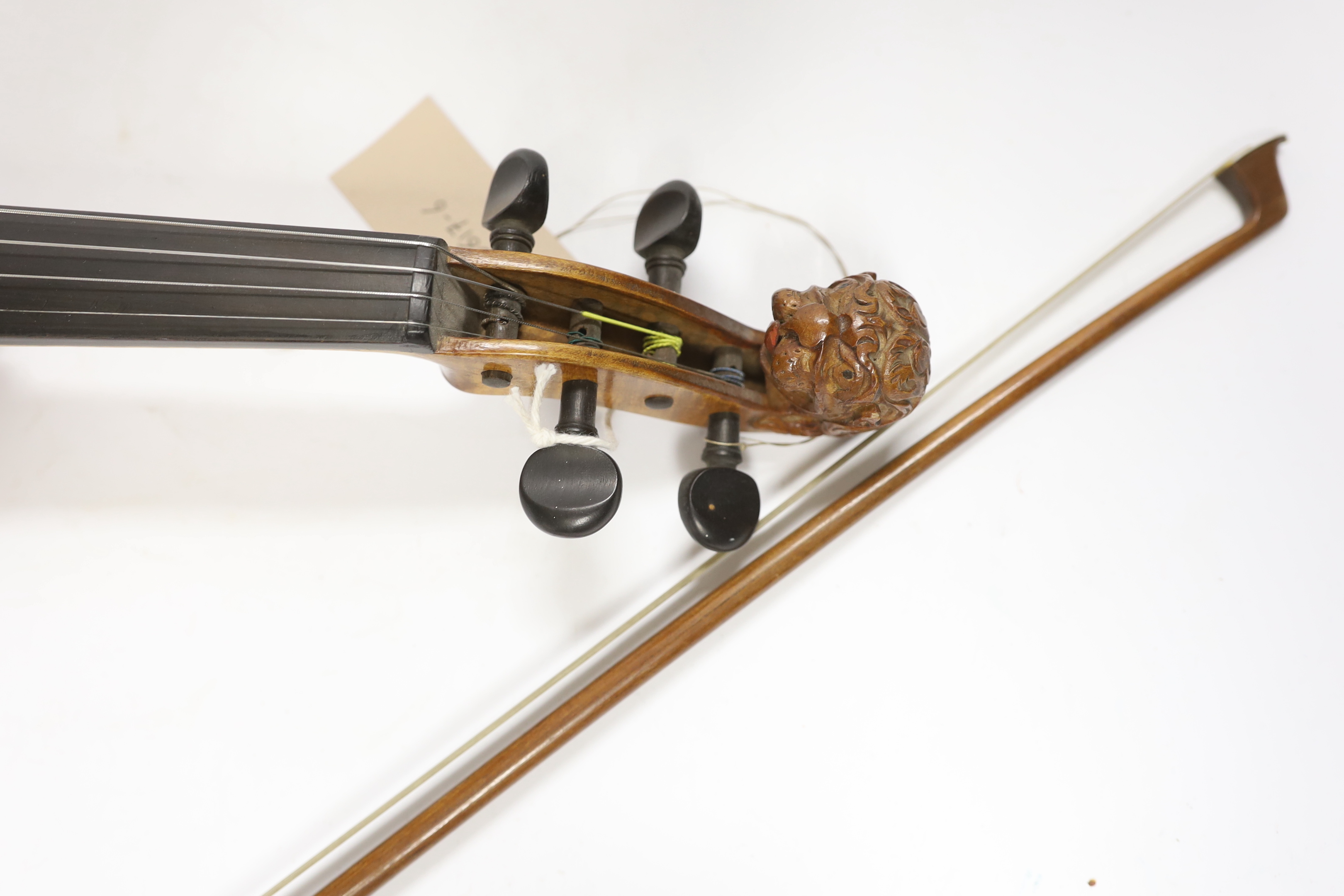 A 'travelling' violin and bow, the violin with grotesque head scroll carving, body 30.5cm